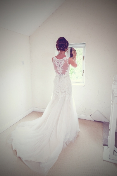 Full length photo of bride in her dress in an all white room at Barnabrow House