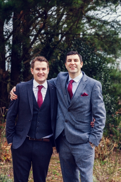 Groom and Best man pose for a photo in the woods