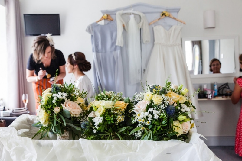 Bride getting ready in the Emmet Hotel Clonakilty with her bouquets in the foreground