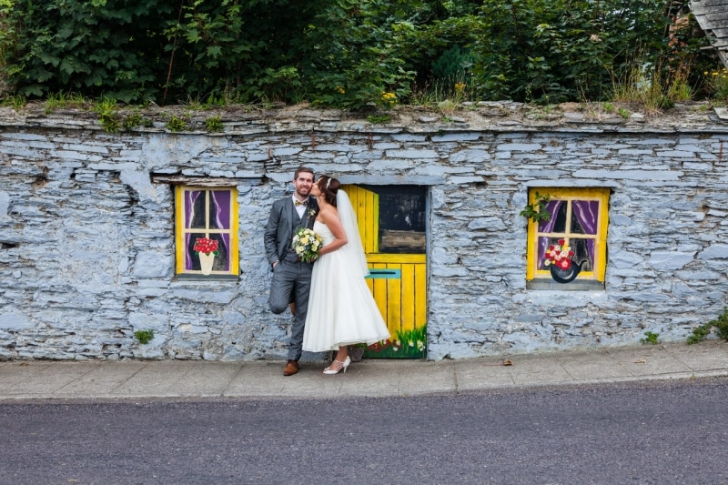 Bride and groom in front of a painted wall in Ring, Clonakilty