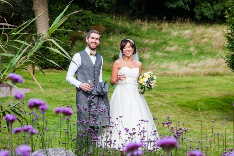 Bride and groom walk through the garden at Fernhill House Hotel