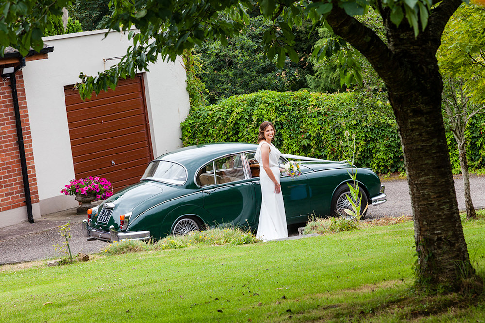Bride exists green classic wedding car