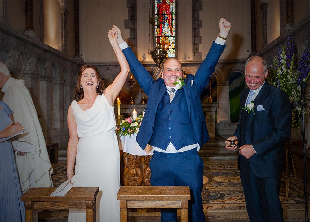 Bride and groom raise their hands in glee