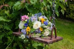 Bridal bouquet rests on a wooden swing