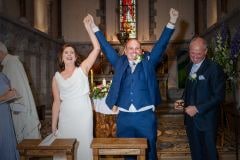 Bride and groom raise their hands in glee