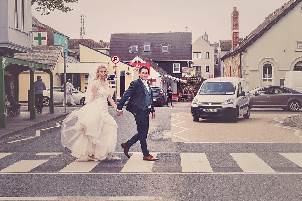 Bride and groom crossing street in Kinsale