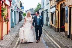 Bride and groom walking down Kinsale alley