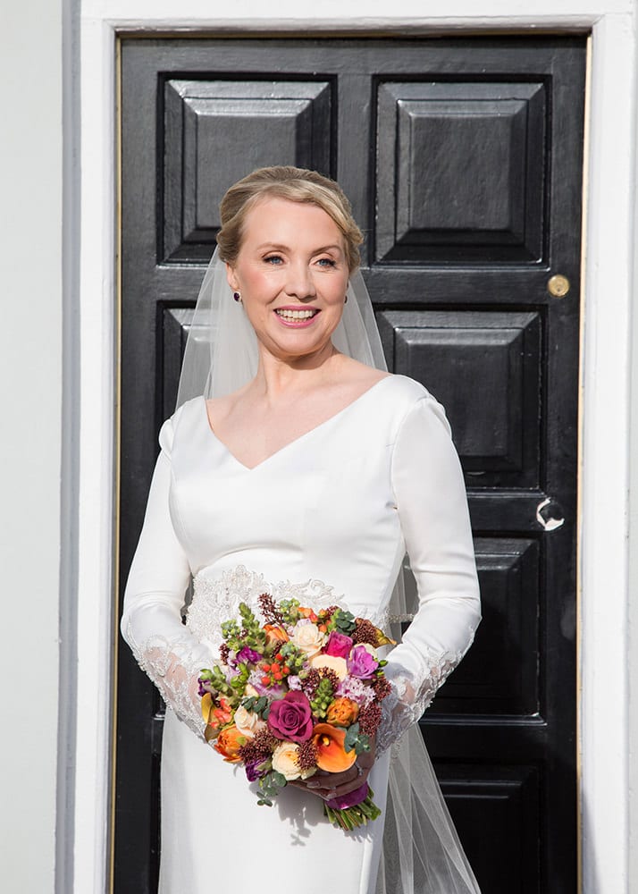 Closeup of bride and her bouquet in front of black Georgian door